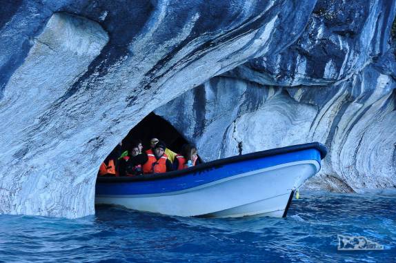 Turistas atravessam um túnel na Catedral de Mármore, no lago General Carrera, região de Puerto Rio Tranquilo, na Carretera Austral, sul do Chile
